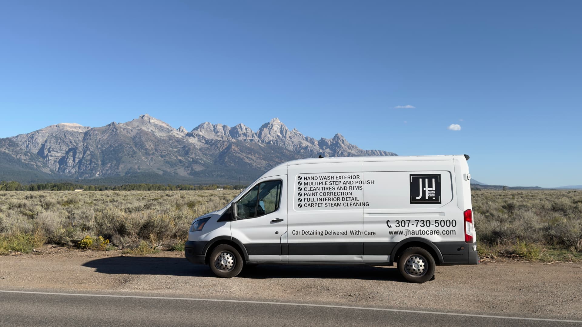 JH Auto Care mobile detailing van parked in Jackson Hole, Wyoming with mountains behind it
